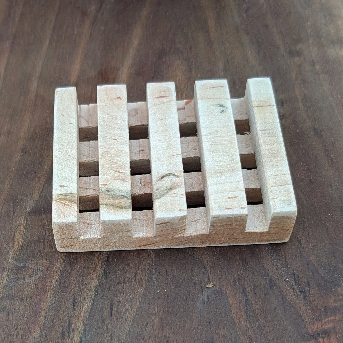 Handcrafted maple wood soap dish made in a Tennessee farm workshop on walnut wood surface
