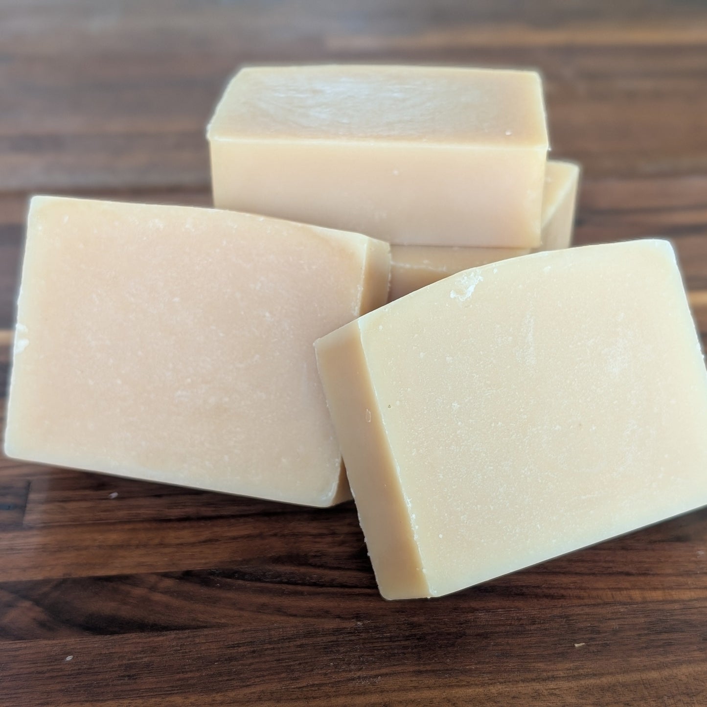 Bloom 'n Goat Pure Unscented fragrance free goat milk soap bars for sensitive skin on a walnut wood background