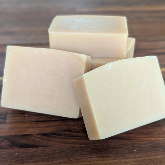 Bloom 'n Goat Pure Unscented fragrance free goat milk soap bars for sensitive skin on a walnut wood background